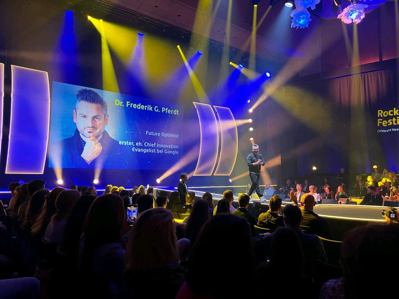 Dr. Frederik G. Pferdt on stage with dramatic festival lighting